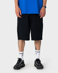 Person wearing black shorts, blue top, and black sneakers on a white background