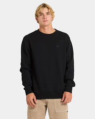 Person wearing a black sweater with a small logo on a light gray background