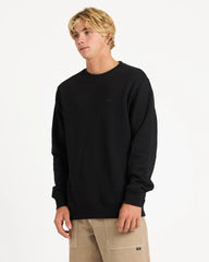 Person wearing a black sweatshirt and beige pants on a white background