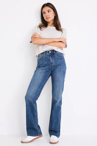 Woman wearing blue jeans and a white shirt against a white background