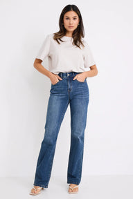 Woman wearing a white top and blue jeans on a white background