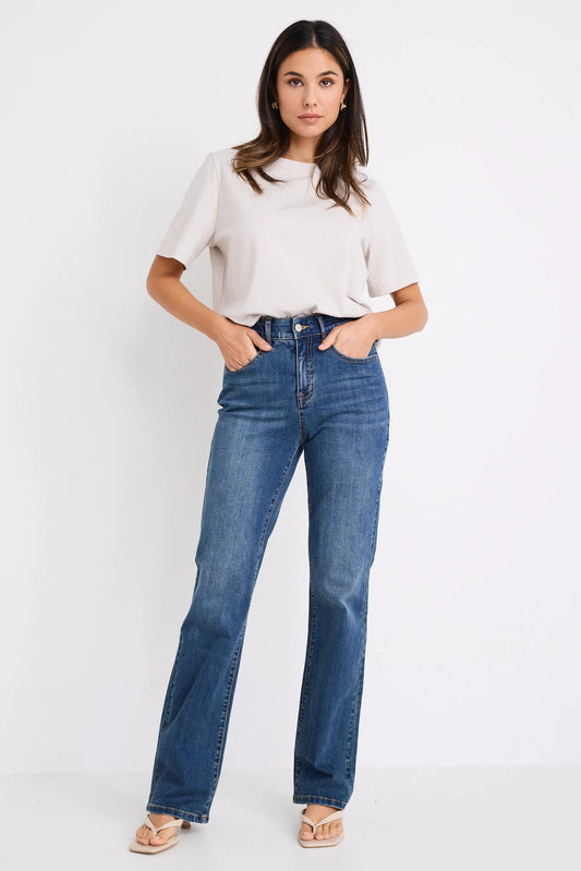 Woman wearing a white top and blue jeans on a white background