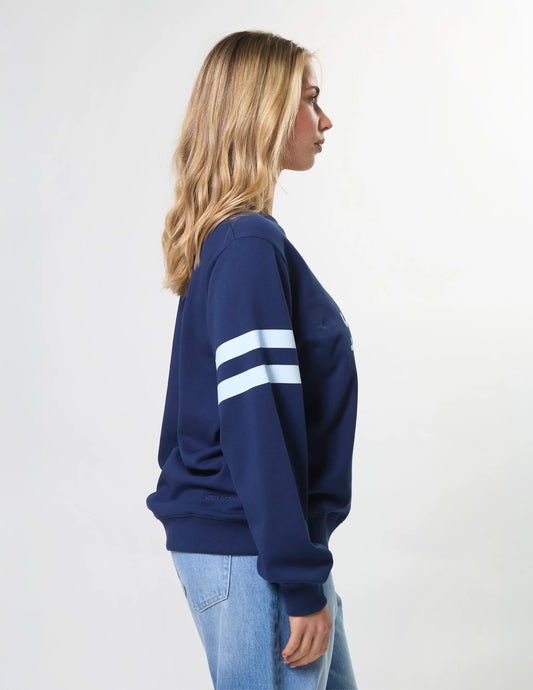 Person wearing a navy blue sweatshirt with white stripes on a plain background