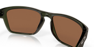 Sunglasses with brown lenses and green frame on a black background