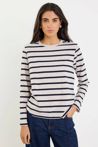 Woman wearing a striped sweater and jeans against a white background