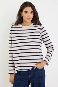 Woman wearing a striped sweater and jeans against a white background