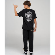Person wearing a black t-shirt and pants with a skull design on a gray background