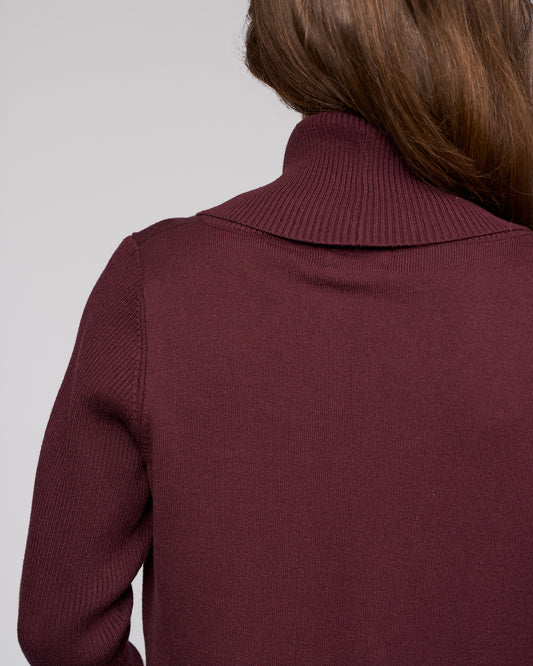 Maroon sweater worn by a person on a light gray background