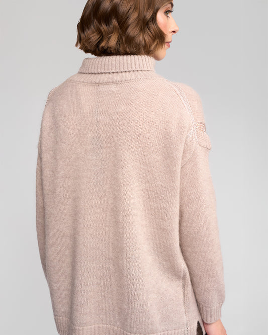 Woman wearing a oat sweater against a gray background
