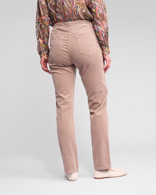 Person wearing beige pants with a patterned shirt on a white background