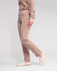 Person wearing beige pants and a patterned shirt on a light gray background