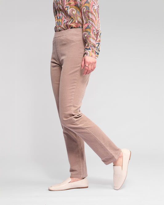 Person wearing beige pants and a patterned shirt on a light gray background