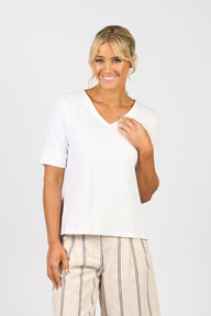 Woman in Vassalli White t-shirt with striped shorts and a white background