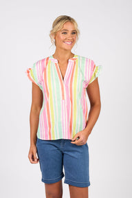 Woman wearing Vassalli colorful striped shirt and denim shorts on a white background