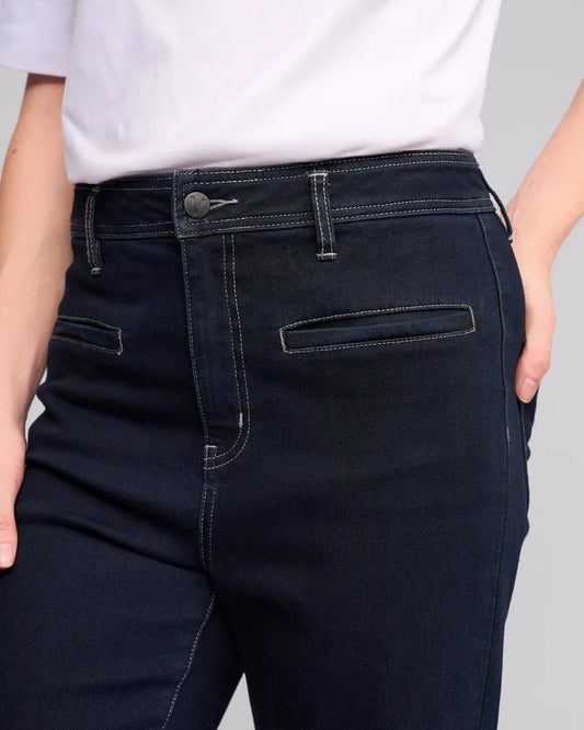 Dark blue jeans worn by a person on a gray background