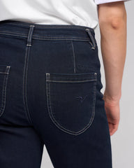 Dark blue jeans with a visible brand logo on a plain background
