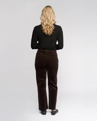 Person wearing a black top and brown pants on a white background