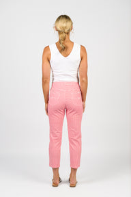 Lady wearing a white tank top and Vassalli red checkered pants on a white background