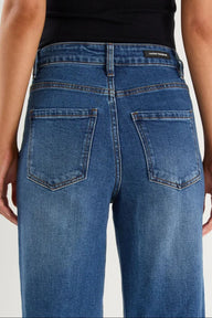 Blue jeans worn by a person on a light gray background