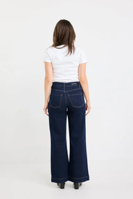 Person wearing blue jeans and a white shirt on a white background